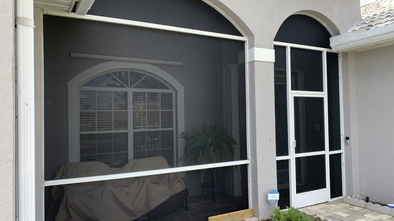 Covered front porch featuring durable mesh and a white-framed door, showcasing professional front entryway screening designed to block pests while enhancing curb appeal.