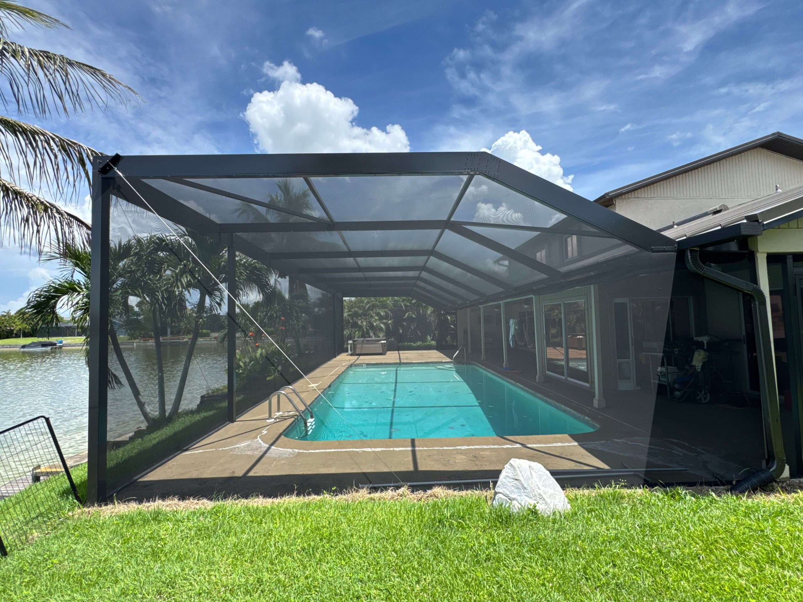 Reverse half-mansard pool screen enclosure overlooking waterfront